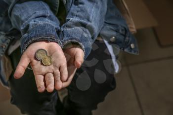 Homeless little boy with coins, closeup�