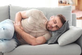 Young man suffering from stomachache at home�