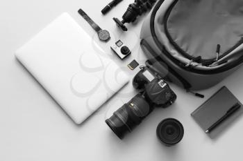 Modern equipment of professional photographer with laptop on light background�