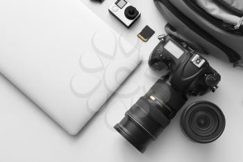 Modern equipment of professional photographer with laptop on light background�