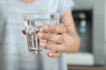 Woman with glass of water indoors, closeup�