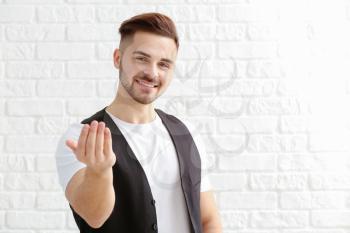 Handsome man showing come here gesture on white background�