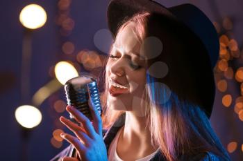 Beautiful female singer with microphone on stage�