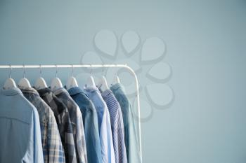 Rack with stylish clothes on grey background�