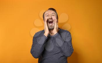 Portrait of screaming mature man on color background�