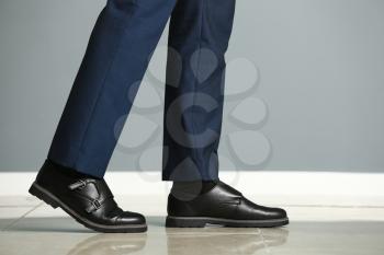 Young man in elegant shoes near color wall�