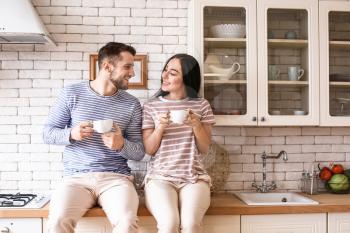 Lovely young couple drinking tea in kitchen�