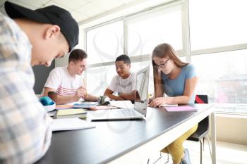 Group of teenagers studying together in school�