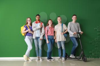 Group of teenagers near color wall�