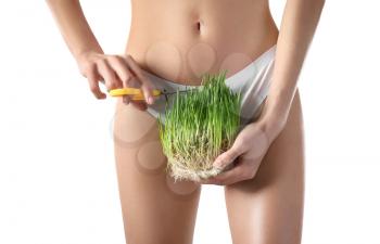 Beautiful young woman with green grass and scissors on white background. Hair removal concept�