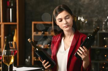 Young female sommelier working in wine cellar�