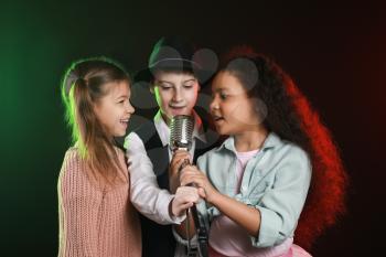 Little children singing in microphone on stage�