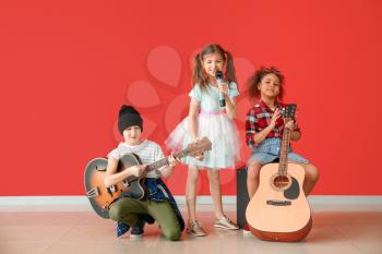 Band of little musicians against color wall�