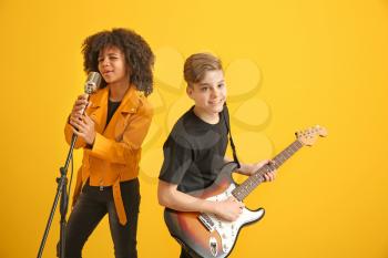 Teenage musicians playing against color background�