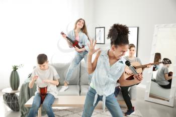 Teenage musicians playing and singing at home�