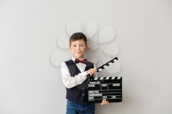 Little boy with clapperboard on white background�