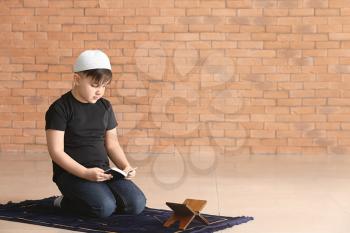 Little Muslim boy praying indoors 