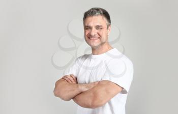 Portrait of handsome mature man on grey background�