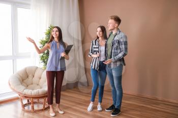 Real estate agent showing young couple a new house�