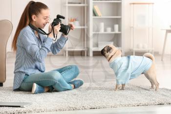 Teenage girl taking photo of her cute dog at home�