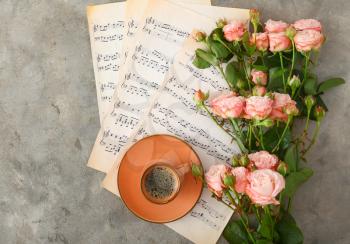 Cup of coffee with music notes and beautiful roses on grunge background�