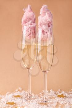 Glasses with tasty cotton candy cocktail on color background�