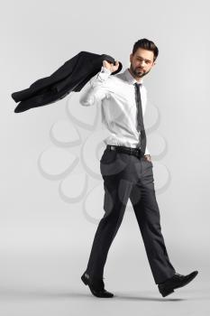 Going young businessman on grey background�