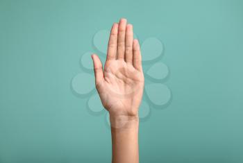 Gesturing female hand on color background�