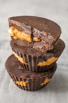 Tasty chocolate peanut butter cups on grey table�
