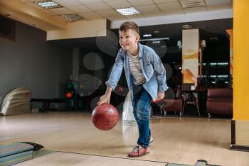 Little boy playing bowling in club�