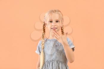 Little deaf mute girl using sign language on color background�