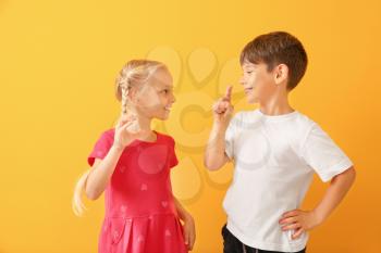 Little deaf mute children using sign language on color background�