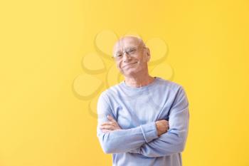 Portrait of happy elderly man on color background�