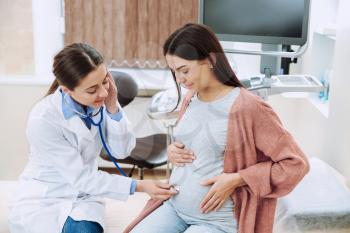 Female gynecologist working with pregnant woman in clinic�