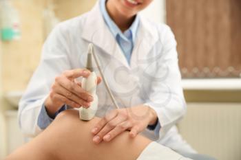 Female doctor conducting ultrasound examination of woman in clinic�