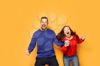 Screaming young couple on color background�