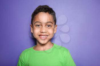 Portrait of cute little boy on color background�