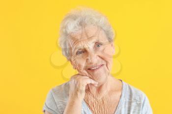Portrait of senior woman on color background�