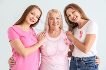 Beautiful women of different ages with pink ribbons on light background. Breast cancer concept�