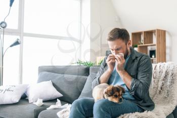 Man suffering from pet allergy at home�