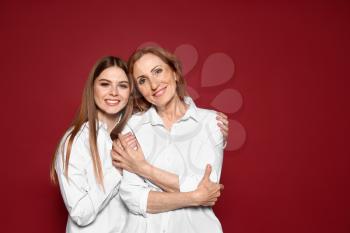 Portrait of happy mother with her daughter on color background�