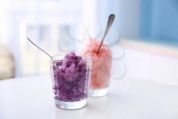 Glasses with tasty shaved ice on white table�
