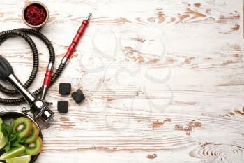 Parts of hookah and fruits on wooden background�