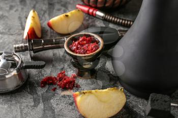 Hookah with tobacco and fresh apple on grey table�