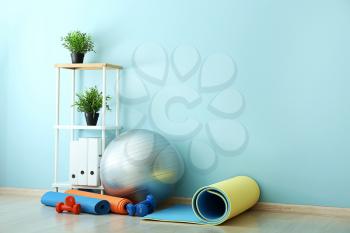 Set of sports equipment with fitness ball near wall�