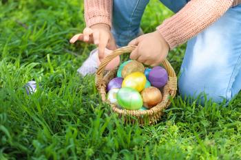 Little girl gathering Easter eggs in park, closeup�