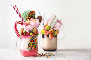 Different delicious freak shakes on light background�