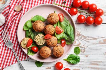 Plate with tasty falafel balls on wooden table�