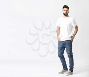 Stylish young man in jeans on white background�