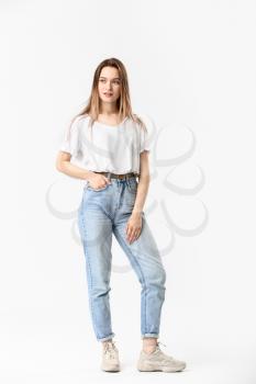 Stylish young woman in jeans on white background�